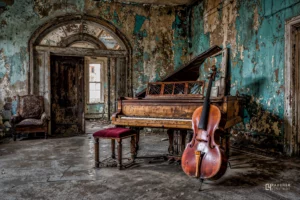 Piano ancien et violoncelle dans une pièce abandonnée aux murs écaillés, photographie fine art de style urbex et artistique.