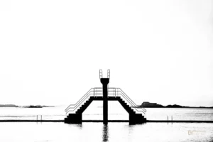 Plongeoir et escaliers symétriques en noir et blanc face à la mer à Saint-Malo, photographie minimaliste fine art.